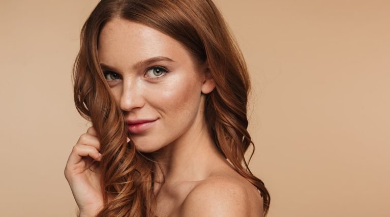 beauty-portrait-mystery-smiling-ginger-woman-with-long-hair-posing-sideways-looking-min